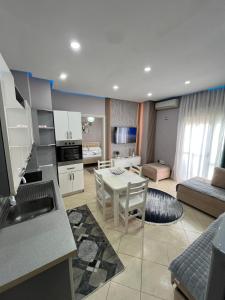 a kitchen and living room with a table and a couch at Flower Apartment Golem in Golem
