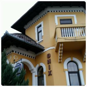 een geel huis met een balkon aan de zijkant bij Pensiunea Onix in Făgăraş