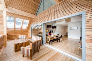 une grande chambre avec des murs en bois et une salle à manger dans l'établissement Fleischerei - Apartments, Cafe & Weinbar, à Hinterstoder