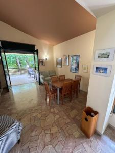 Una sala de estar con una mesa y sillas y un sofá. en Villa Pineta - Parcheggio, Giardino, Wi-Fi, Tavolo Ping Pong - Oasi di Tranquillità a Due Passi dal Mare, en Lignano Sabbiadoro