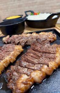a bunch of meat on a grill with two pans at Hotel Jenipapo in Salinas +13 photos