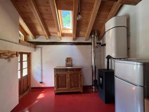 a kitchen with a refrigerator and a wooden ceiling at Riverside Rooms Emma For young and wild spirits in Pontboset +24 photos