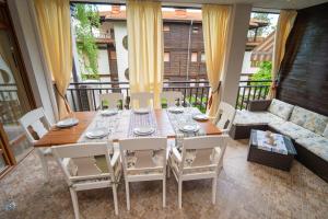 una sala da pranzo con tavolo, sedie e divano di SeaRent Dream Home in Santa Marina - 2 bedrooms, 2 baths and a HUGE terrace a Sozopol