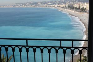 a view of the beach and ocean from a balcony at Hotel Suisse in Nice