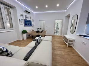 a living room with a white couch and a table at Grand Apartment Piran in Piran