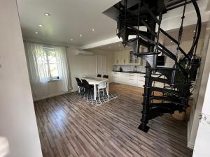 a living room with a table and a spiral staircase at Sörbyvägen 6 in Floby