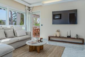 a living room with a couch and a table at New Renovated Front Line Beach Playa Rocio Puerto Banus in Marbella