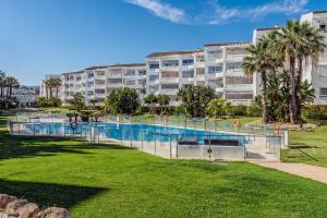 a swimming pool in front of a large apartment building at New Renovated Front Line Beach Playa Rocio Puerto Banus in Marbella
