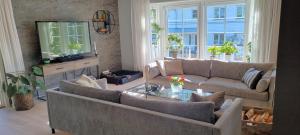 a living room with two couches and a television at Detached house close to nature and city life in Oslo
