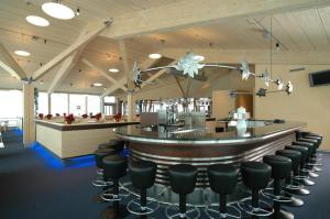a bar in a restaurant with black chairs at Berghaus Männlichen in Grindelwald