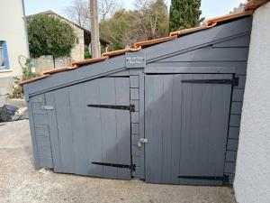 Buzet-sur-BaïseにあるGite d'étape Canal de Garonneの建物にある一対の灰色のガレージドア