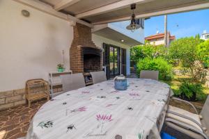 Un comedor con mesa y chimenea. en VILA OLIVE TREE Krk, en Kornić