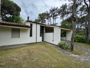 una casa blanca con patio en Villa Pineta - Parcheggio, Giardino, Wi-Fi, Tavolo Ping Pong - Oasi di Tranquillità a Due Passi dal Mare, en Lignano Sabbiadoro