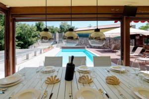 a dining table with wine glasses and a view of a pool at Villa Prosecco x 13 Piscina & Barbecue in Prosecco