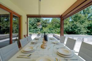 a dining room with a long white table and chairs at Villa Prosecco x 13 Piscina & Barbecue in Prosecco