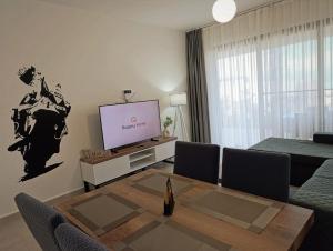 un salon avec une télévision et une table dans l'établissement Family large apartment in Bahçeli, à Aglantzia