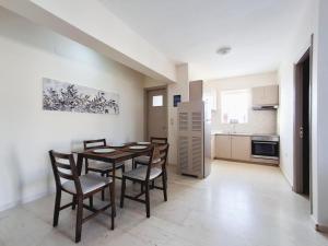 a kitchen and dining room with a table and chairs at Tasias apartments in Lixouri
