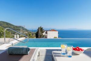 格洛萨Villa Soultani的从别墅里看到的泳池景观，配有一张桌子