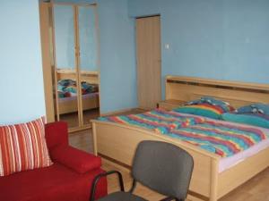 a bedroom with a bed and a red chair at Restaurace 96 in Košice