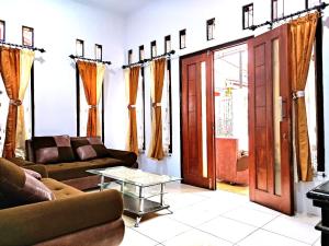 a living room with two couches and a table at Denisa homestay Kuningan 2 in Mantaak +1 photo