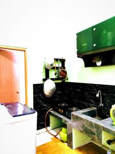 a kitchen with a sink and a camera on a counter at Denisa homestay Kuningan 2 in Mantaak