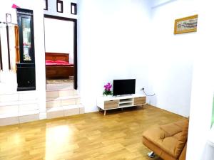 a living room with a television and a couch at Denisa homestay Kuningan 2 in Mantaak