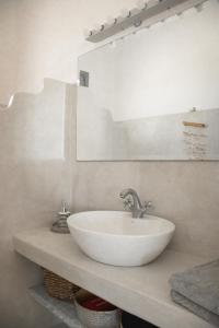 a bathroom with a white sink and a mirror at Vicky's Guest House in Patmos +22 photos
