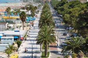 a city street with palm trees and a beach at Casamare in Roseto degli Abruzzi