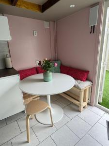 a small kitchen with a white table and a couch at Guesthouse West in Noordwijk