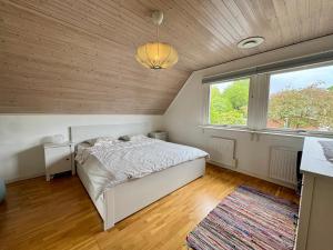 a bedroom with a bed and a large window at Family home in Älmhult