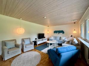 a living room with a couch and chairs and a tv at Family home in Älmhult