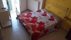 a bed with a red and white quilt on it at b&b TEATRO in Bisceglie