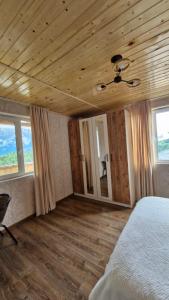 a bedroom with a bed and a wooden ceiling at Guest house Calgmli in Kichkhuldashi
