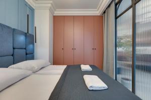 een slaapkamer met een bed met twee handdoeken erop bij Żurawie IKONY 1 by Grand Apartments in Gdańsk