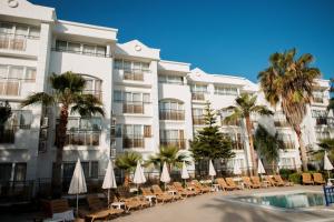 a hotel with chairs and a swimming pool and palm trees at Club Golf Hotel All Inclusive in Side