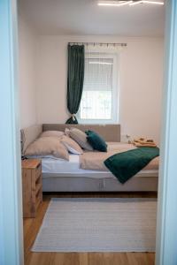 a bedroom with a large bed with a window at Bella Apartman in Nyíregyháza
