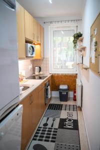 a small kitchen with a black and white rug on the floor at Bella Apartman in Nyíregyháza +8 photos