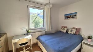 una camera da letto con un letto, una scrivania e una finestra di Aloha Beach Terrace - Holiday Home a Siófok