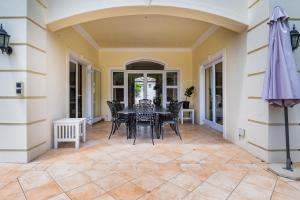 a dining room with a table and chairs on a patio at Luxury Family Villa Near Beach with Grill and Workspace in Cape Town