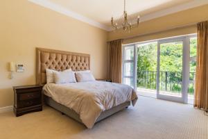 a bedroom with a large bed and a large window at Luxury Family Villa Near Beach with Grill and Workspace in Cape Town +36 photos