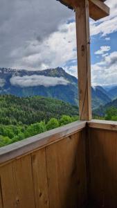 a window in a wooden cabin looking out at the mountains at Guest house Calgmli in Kichkhuldashi