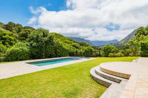 a swimming pool in a yard with mountains in the background at Luxury Family Villa Near Beach with Grill and Workspace in Cape Town