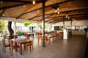 a restaurant with wooden tables and chairs on a deck at Club Golf Hotel All Inclusive in Side
