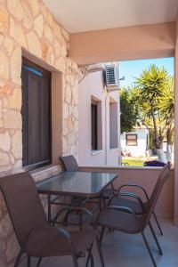 a table and chairs on a balcony with a window at Liogerma Apartments in Pefkochori