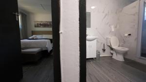a bathroom with a bed and a toilet and a sink at Grace Avenue Bungalow in Port Edward