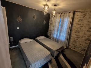 Un dormitorio con dos camas y una pared de ladrillo. en Maison T3, en La Seyne-sur-Mer