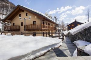 a house in the snow with snow piled up at Appartamenti Residenza Anderbatt in Gressoney-la-Trinité
