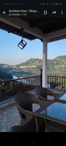 a balcony with chairs and a table with a view at Eldora - Luxury of Leisure in Nainital