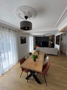 a living room with a wooden table and chairs at Maison 3ch proche circuit 24h et boulerie jump in Saint Pavace