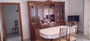 a dining room with a table and a wooden cabinet at Apartamento Moraledas in Lanjarón